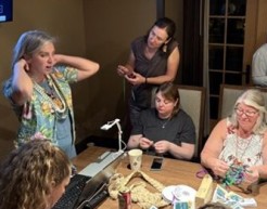 A group of educators take part in a group activity at a conference table.