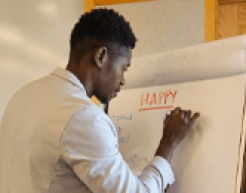 Jeftey Saint Fleur writes on a large easel pad