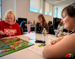 People sit at a table and play the ATi board game
