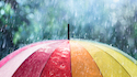 Raindrops fall on a rainbow-colored umbrella