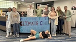 A group photo of students from the Climate Ed Student Leadership Team in front of a banner that says, Welcome to the climate change solutions museum 