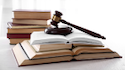 A gavel sits atop a stack of opened books