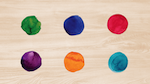 Six paint splotches of different colors on a artist's palette