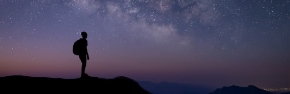 Silhouette of young traveler and backpacker watched the star and milky way alone on top of the mountain.